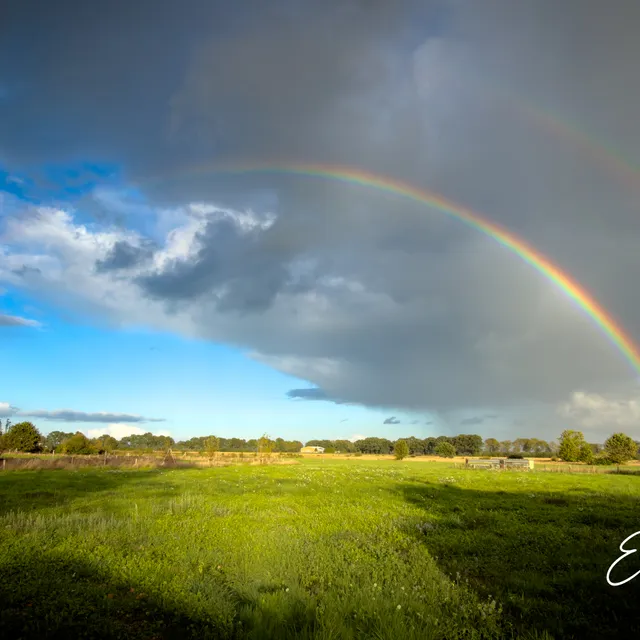 Dubbele regenboog boven het landschap